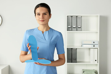 Sticker - Beautiful female orthopedist showing insole in hospital