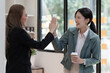 © NanSan - Female business worker with colleagues in Thailand working together at office desk, getting high five, teamwork concept