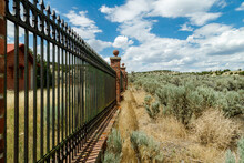 Stone And Metal Fence In The Desert During The Summer
