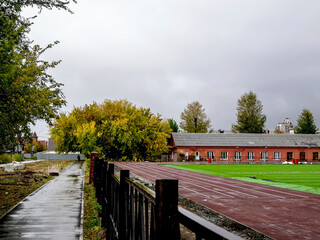 Wall Mural - cloudy autumn landscape near the school stadium