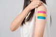 © Kiattisak - Happy young woman after getting a vaccine. showing shoulder arm with bandage after receiving vaccination, herd immunity, side effect, booster dose, vaccine passport and Coronavirus pandemic