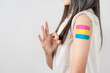 © Kiattisak - Happy young woman show ok sign after getting a vaccine. showing shoulder with bandage after receiving vaccination, herd immunity, side effect, booster dose, vaccine passport and Coronavirus pandemic