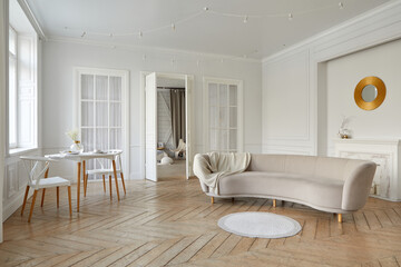 Interior of light lounge with white walls and solid herringbone oak parquet with round table decorative lights on ceiling and oval beige sofa