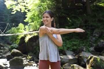 Canvas Print - Happy young woman doing morning exercise in mountains