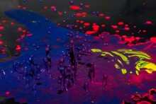 Colorful Neon Magnetic Liquid Drops Rising Up On A Dark Background