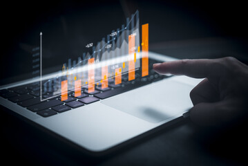 Businessperson using laptop computer with chart. business investment and financial concept of growth economic. Investor data analysis for planning in strategy of stock market fund.