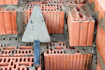  Construction trowel for laying bricks and blocks. Construction tool of a bricklayer. Hand working tool on the background of brickwork.
