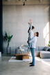 © F8  \ Suport Ukraine - Happy romantic couple having fun in new home, man holding womans hand up leading in dance enjoying weekend, cheerful young family feeling excited spending time together in cozy modern living room