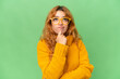 © luismolinero - Young caucasian woman isolated on green screen chroma key background With glasses and looking up