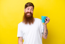 Redhead Man With Beard Holding A Mug Isolated On Yellow Background With Happy Expression