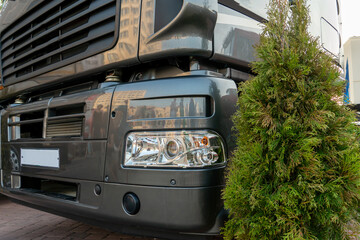 A big truck on the road. Modern new halogen headlights on a truck. Truck headlights.  Square red headlight and reflector on the back of the hood. Car detail, close-up.