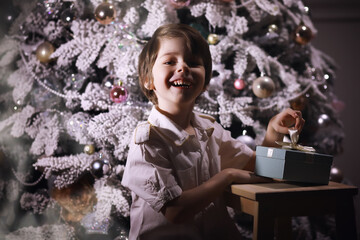 Wall Mural - Child in smart clothes in front of the Christmas tree. New Years Eve. Waiting for the new year.