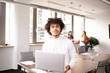 © jessica - Young man in the office, in foreground looking at the camera with his laptop