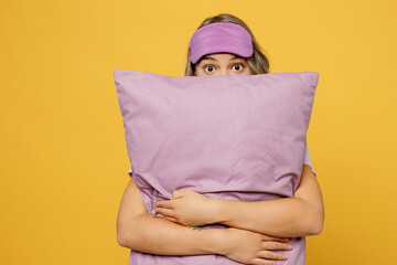 Wall Mural - Worry scared young woman in pajamas home wear sleep eye mask hold purple sheet pillow spending time in bedroomisolated on yellow background. Bad mood concept. Woke up from terrified freddy nightmare.