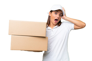 Wall Mural - Delivery caucasian woman holding boxes isolated on green chroma background with surprise expression