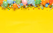 Birthday background top view. Balloons and various party decorations on a yellow background with copy space