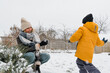 Winter games. Family playing snowballs in the courtyard of the house. winter, game, snow, christmas games, snow games, snowball fights, activity in winter,cottagecore,countryside