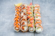 Set of maki sushi rolls with tuna, salmon, shrimp, avocado, cream cheese, red flying fish caviar, sauce and lime.