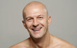 © Clique Images - Horizontal studio portrait of handsome adult man with bald head smiling