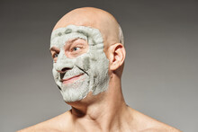 Portrait Of Mature Man With Dry Bentonite Clay Mask Making Silly Smiling Face