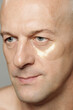 © Clique Images - Beauty portrait of modern adult man using moisturising under-eye patches