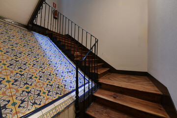 Wall Mural - Interior stairs with wooden steps in an old apartment building with decorative tiles