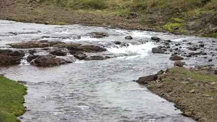 Wall Mural - Fantastic landscape with flowing rivers and streams with rocks and grass in Iceland.