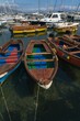 Vertical shot of colorful wooden row boats found anchored at a pier