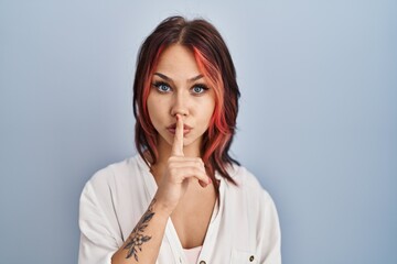 Canvas Print - Young caucasian woman wearing casual white shirt over isolated background asking to be quiet with finger on lips. silence and secret concept.