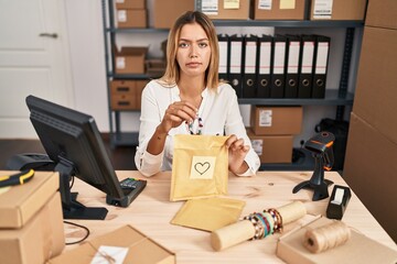 Canvas Print - Young blonde woman working at small business ecommerce relaxed with serious expression on face. simple and natural looking at the camera.