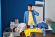 © Krakenimages.com - Young hispanic man ironing clothes at home smiling with hand over ear listening and hearing to rumor or gossip. deafness concept.