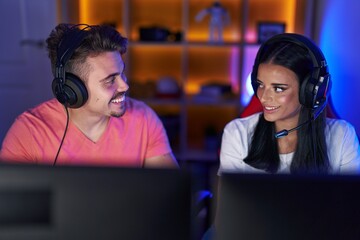 Wall Mural - Man and woman streamers playing video game using computer at gaming room