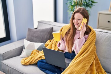 Sticker - Young caucasian woman talking on smartphone drinking coffee at home