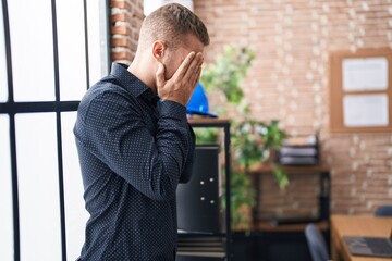 Wall Mural - Young caucasian man business worker standing with arms crossed gesture and worried expression at office