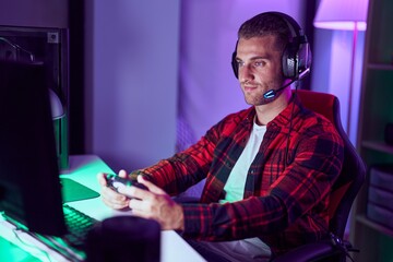 Canvas Print - Young caucasian man streamer playing video game using joystick at gaming room