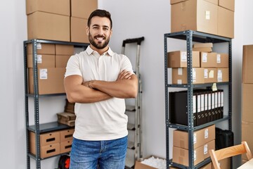 Canvas Print - Young hispanic man smiling confident standing with arms crossed gesture at storehouse