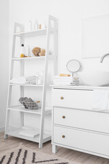 Poster - Chest of drawers with modern sink and shelf unit with bath accessories near white wall