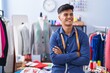 © Krakenimages.com - Young hispanic man tailor smiling confident standing with arms crossed gesture at clothing factory