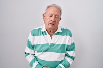 Canvas Print - Senior man with grey hair standing over white background with hand on stomach because indigestion, painful illness feeling unwell. ache concept.