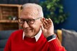 © Krakenimages.com - Senior man smiling confident using deafness hearing aid at home