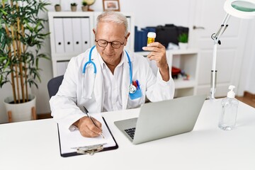 Canvas Print - Senior man wearing doctor uniform prescribe pills treatment at clinic