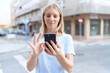 © Krakenimages.com - Young blonde woman smiling confident using smartphone at street
