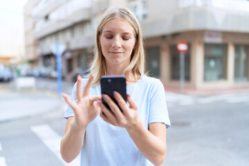 Sticker - Young blonde woman smiling confident using smartphone at street