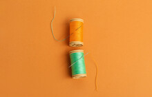 Thread Spools With Needles On Color Background
