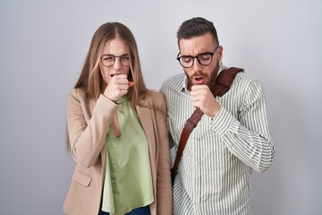 Wall Mural - Young couple standing over white background feeling unwell and coughing as symptom for cold or bronchitis. health care concept.