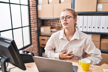 Poster - Young caucasian woman working at small business ecommerce using laptop with hand on stomach because indigestion, painful illness feeling unwell. ache concept.