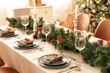 Christmas table setting with fir branches and rowan in dining room