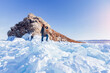 Winter landscape woman tourist Lake Baikal frozen ice hummocks sunny day