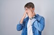 © Krakenimages.com - Caucasian blond man standing wearing glasses rubbing eyes for fatigue and headache, sleepy and tired expression. vision problem