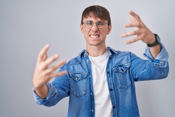 Sticker - Caucasian blond man standing wearing glasses shouting frustrated with rage, hands trying to strangle, yelling mad